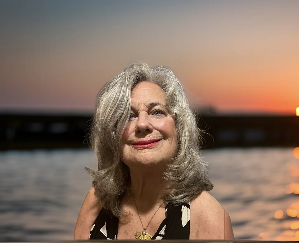 Biography portrait: Jude Neale against sunset light over the water. This is biography context, not part of the artistic-photography portfolio.